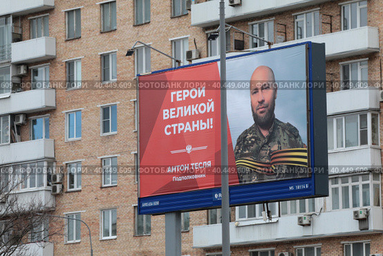 Подполковник Антон Тесля рекламный банер на фоне жилого дома (2023 год). Редакционное фото, фотограф Дмитрий Неумоин / Фотобанк Лори