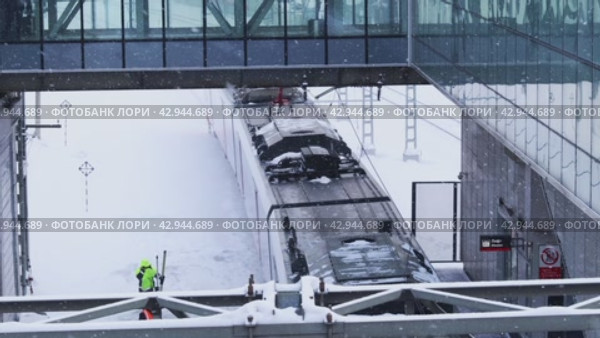 Поезд МЦК приезжает на станцию. Городской транспорт зимой. (2023 год). Редакционное видео, видеограф Константин Григорьев / Фотобанк Лори