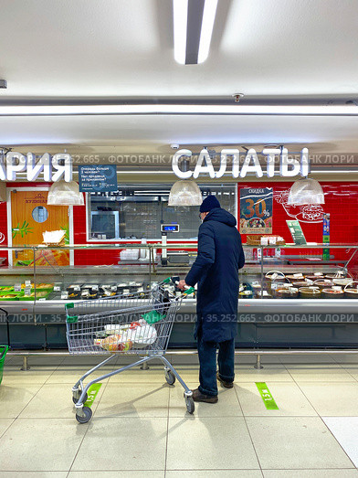 Покупатель с тележкой в отделе кулинарии в супермаркете (2021 год). Редакционное фото, фотограф Мария Кылосова / Фотобанк Лори