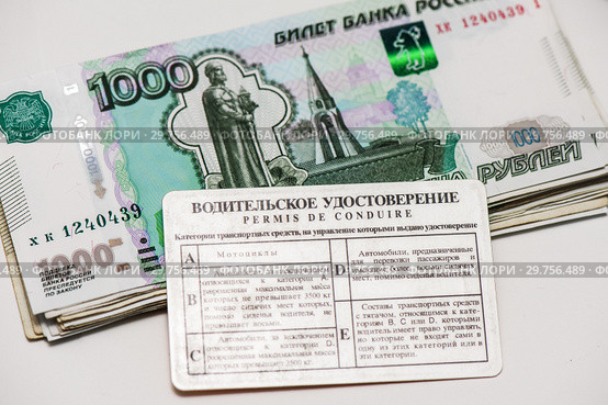 Получение прав. Водительское удостоверение и пачка российских денег на светлом фоне. Стоковое фото, фотограф Игорь Низов / Фотобанк Лори