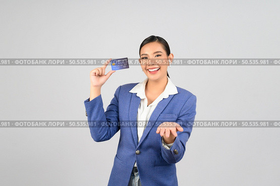 Portrait Asian young woman in officer uniform showing credit card in hand and open palm, copy space for insert advertising your product,  isolated on white background. Стоковое фото, агентство Ingram Publishing / Фотобанк Лори