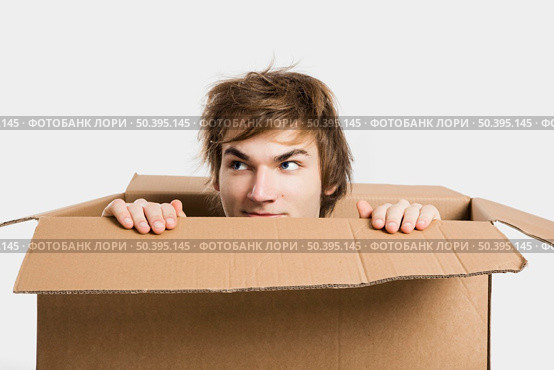 Portrait of a handsome young man inside a cardbox. Стоковое фото, агентство Ingram Publishing / Фотобанк Лори