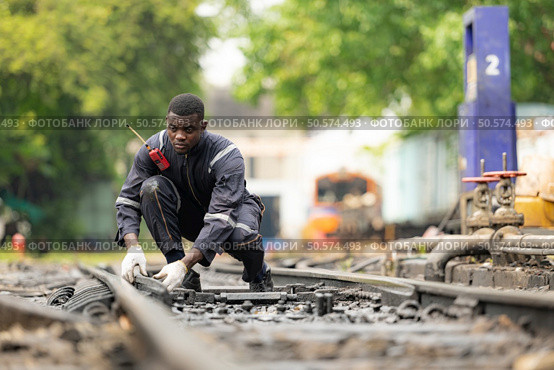 Portrait of a railway engineer on the tracks of a train in station platform. Стоковое фото, агентство Ingram Publishing / Фотобанк Лори