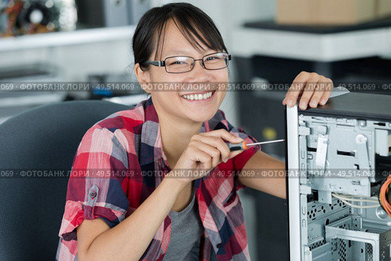 portrait of a smily woman fixing a computer at work. Стоковое фото, агентство Ingram Publishing / Фотобанк Лори