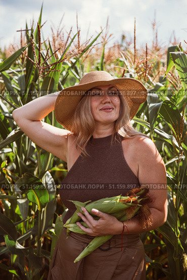 Portrait of a woman farmer in a cornfield.Woman farmer harvesting corn. Стоковое фото, фотограф Юлия Киселёва / Фотобанк Лори