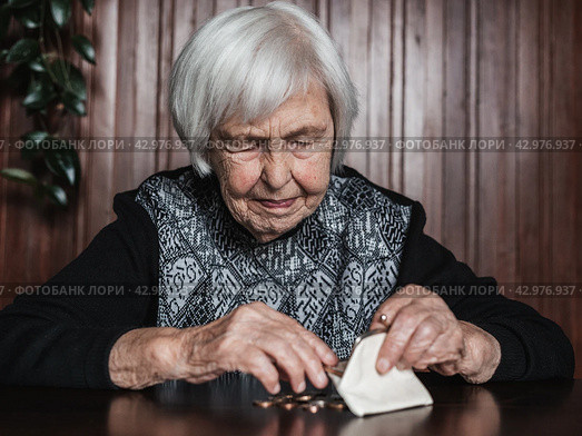 Portrait of an old woman counting money. The concept of old age, poverty, austerity. Стоковое фото, фотограф Matej Kastelic / Фотобанк Лори