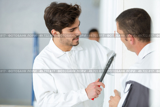 portrait of apprentice scraping wall edge. Стоковое фото, агентство Ingram Publishing / Фотобанк Лори