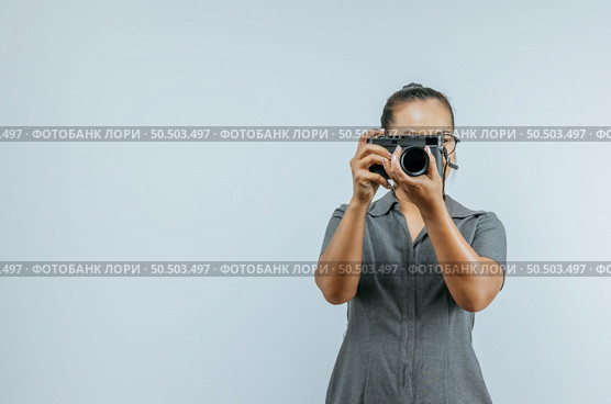 Portrait of Asian woman glasses wearing casual clothes taking a pictures with camera. Isolated background in studio with blank space. Стоковое фото, агентство Ingram Publishing / Фотобанк Лори