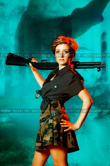 Portrait of attractive woman in military style holding gun in hands. Стоковое фото, агентство Ingram Publishing / Фотобанк Лори