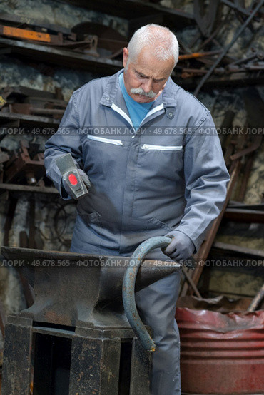 portrait of blacksmith forging metal. Стоковое фото, агентство Ingram Publishing / Фотобанк Лори