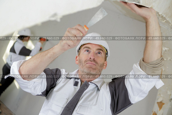 portrait of builder removing the wallpaper. Стоковое фото, агентство Ingram Publishing / Фотобанк Лори