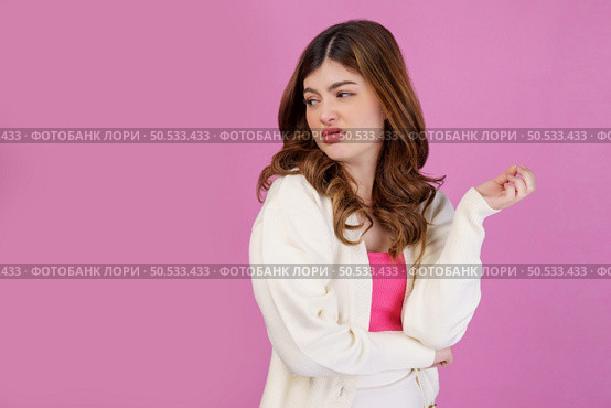 Portrait of disgusted young woman looking something isolated over pink background. People lifestyle and expression concept. Стоковое фото, агентство Ingram Publishing / Фотобанк Лори