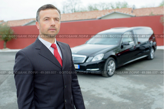 Portrait of funeral director in front of hearse. Стоковое фото, агентство Ingram Publishing / Фотобанк Лори