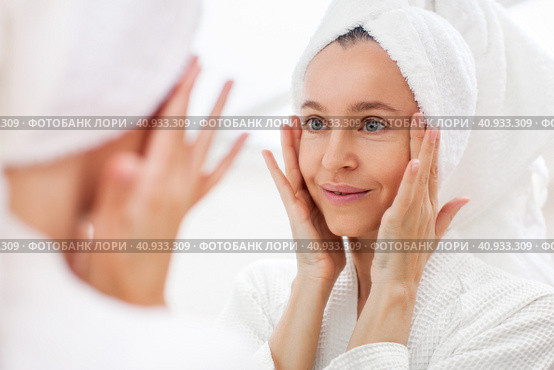 portrait of gorgeous happy middle age woman looking at mirror touching her skin. Стоковое фото, фотограф Гладских Татьяна / Фотобанк Лори