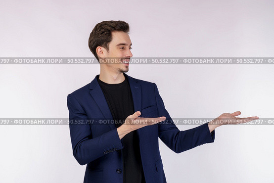 Portrait of happy smiling young businessman presenting and showing your text or product isolated on white background. Empty copyspace area for slogan or advertising text message. Стоковое фото, агентство Ingram Publishing / Фотобанк Лори