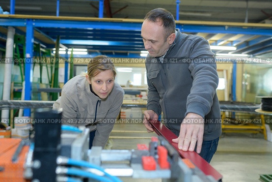 portrait of man and woman inserting metal plates. Стоковое фото, агентство Ingram Publishing / Фотобанк Лори