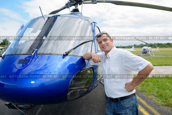 portrait of pilot standing in front of helicopter. Стоковое фото, агентство Ingram Publishing / Фотобанк Лори