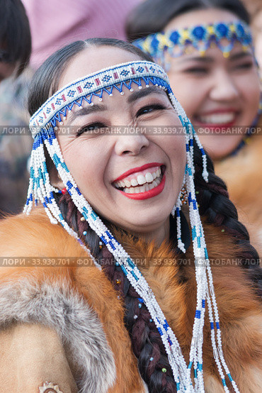 Portrait of smiling expression female in national clothing indigenous inhabitants of Kamchatka. Celebration Koryak traditional holiday Hololo Day of Seal (2018 год). Редакционное фото, фотограф А. А. Пирагис / Фотобанк Лори