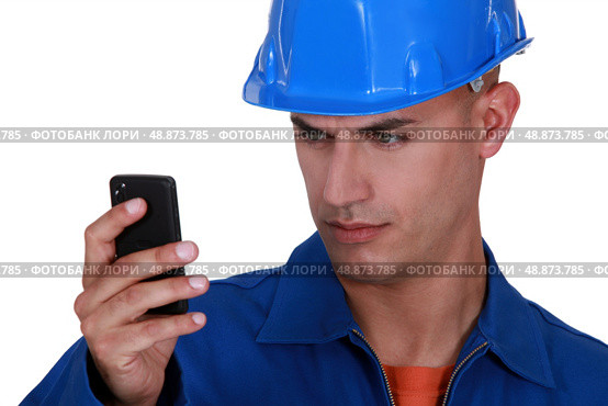 portrait of young blue collar reading sms against white background. Стоковое фото, агентство Ingram Publishing / Фотобанк Лори