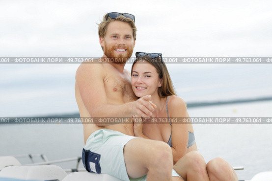 portrait of young couple wearing swimwear on pedalo. Стоковое фото, агентство Ingram Publishing / Фотобанк Лори