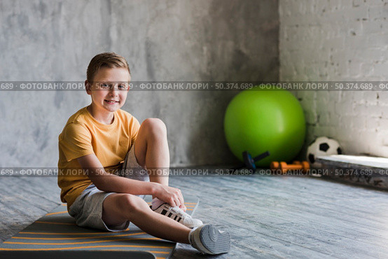 portrait smiling boy sitting exercise mat looking camera. Стоковое фото, агентство Ingram Publishing / Фотобанк Лори