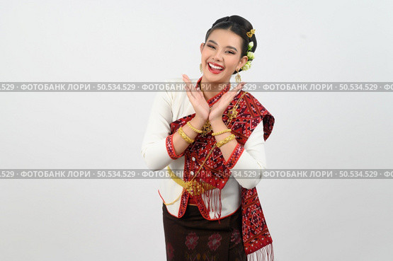 Portrait Young beautiful woman in northeastern dress, she raising hand in Thai dance with charming smile on white background, copy space . Стоковое фото, агентство Ingram Publishing / Фотобанк Лори
