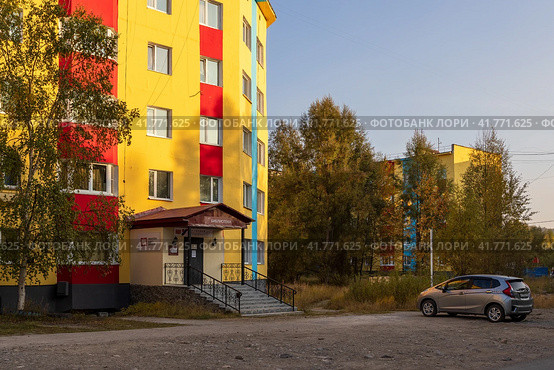 Поселок городского типа Палатка, Магаданская область, Дальний Восток России. Вид на улицу и красочные разноцветные здания. Над входом надпись «БИБЛИОТЕКА». Редакционное фото, фотограф Андрей Степанов / Фотобанк Лори