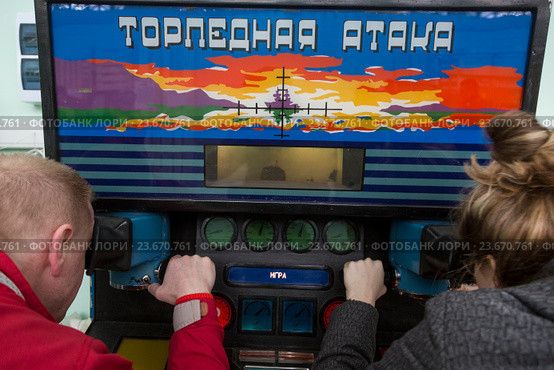 Посетители выставки электронных игр и игровых автоматов в павильоне Зерно на ВДНХ играют на в Морской бой, Москва (2015 год). Редакционное фото, фотограф Николай Винокуров / Фотобанк Лори