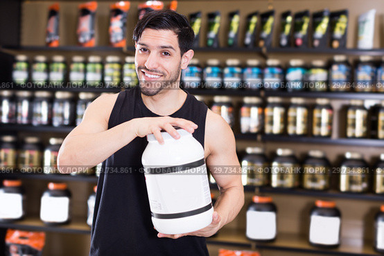 Positive attractive sportman demostration sport nutrition in shop. Стоковое фото, фотограф Яков Филимонов / Фотобанк Лори