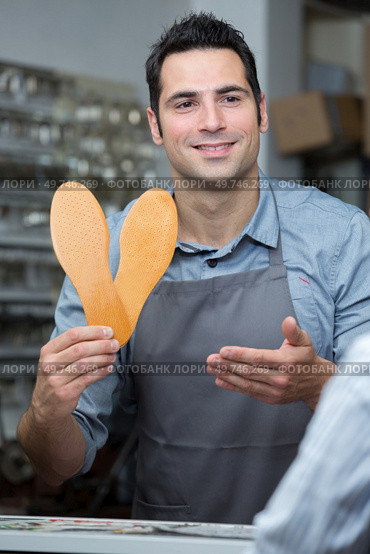 positive professional consultant offering orthopaedic insoles in store. Стоковое фото, агентство Ingram Publishing / Фотобанк Лори