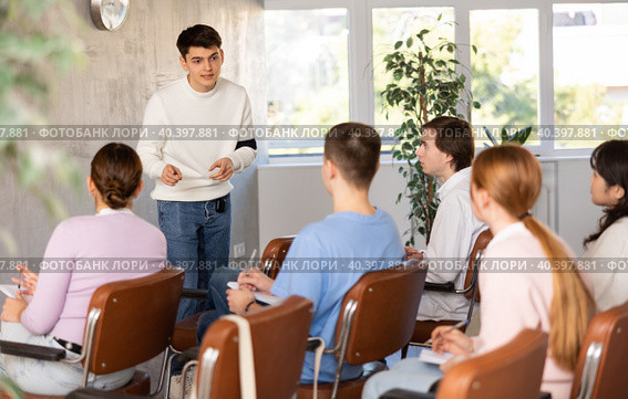 Positive student answering at lesson in front of groupmates. Стоковое фото, фотограф Яков Филимонов / Фотобанк Лори
