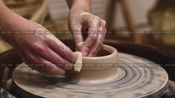 Potter girl works on potter's wheel, making ceramic pot out of clay in pottery workshop. Art and hobby concept. slow motion. Стоковое видео, видеограф Ольга Ильина / Фотобанк Лори