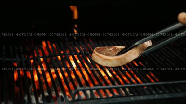 Повар выкладывает мясо на решетку гриля. Стоковое видео, видеограф Алексей Кокорин / Фотобанк Лори