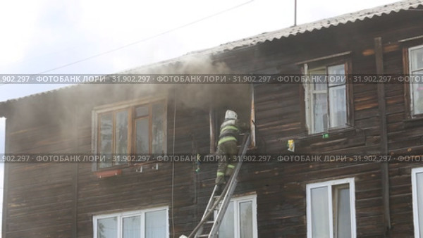 Пожар в старом двухэтажном бараке. Пожарные тушат огонь с выдвижной лестницы. Стоковое видео, видеограф Евгений Ткачёв / Фотобанк Лори