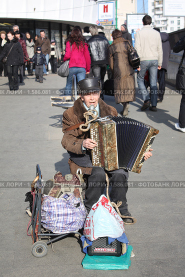 Пожилой мужчина играет на гармошке возле метро (2010 год). Редакционное фото, фотограф Alechandro / Фотобанк Лори