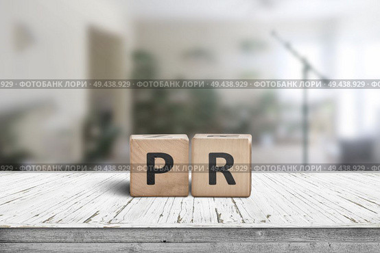 PR sign on a worn table in a bright room with green plants and a microphone. Стоковое фото, агентство Ingram Publishing / Фотобанк Лори