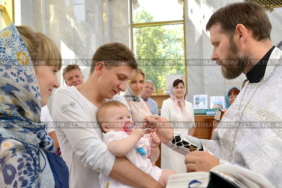 Православный священник совершает помазание елеем младенца перед погружением в воду. Обряд крещения (2013 год). Редакционное фото, фотограф Ирина Борсученко / Фотобанк Лори