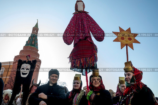 Праздничное шествие в русских национальных костюмах во время празднования Масленицы на Манежной площади на фоне башен Московского кремля в центре города Москвы в рамках фестиваля "Московская Масленица", Россия (2020 год). Редакционное фото, фотограф Николай Винокуров / Фотобанк Лори