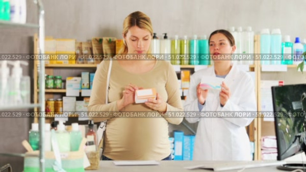 Pregnant woman choosing pills with help of pharmacist. Стоковое видео, видеограф Яков Филимонов / Фотобанк Лори
