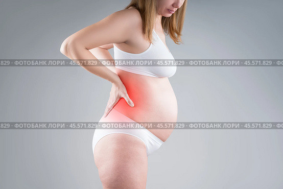 Pregnant woman with back pain, kidney inflammation, risk of premature birth, health problems during pregnancy. Стоковое фото, фотограф Станислав Тарко / Фотобанк Лори