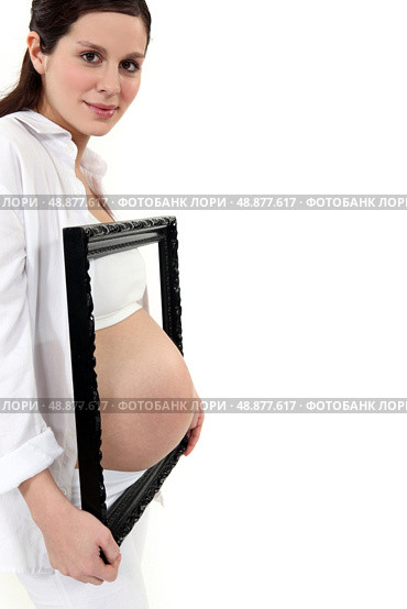 Pregnant woman with picture frame. Стоковое фото, агентство Ingram Publishing / Фотобанк Лори