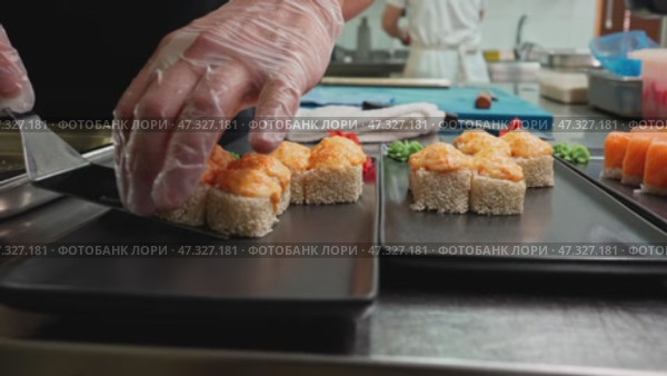 Preparing sushi with fresh ingredients in a busy kitchen setting during midday hours. Стоковое видео, видеограф Сергей Толмачёв / Фотобанк Лори