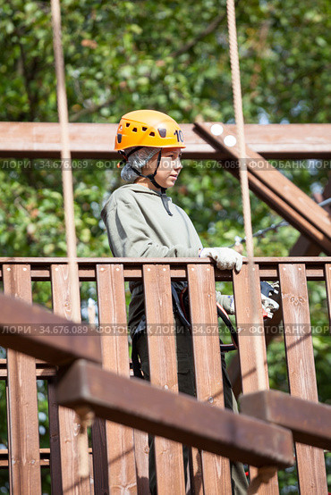 Preteen girl starting an obstacle course wearing climbing equipment, adventure park. Стоковое фото, фотограф Кекяляйнен Андрей / Фотобанк Лори