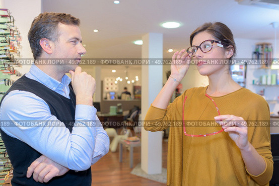 pretty female try eyeglasses with optician. Стоковое фото, агентство Ingram Publishing / Фотобанк Лори