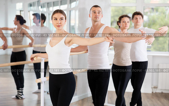Pretty young girl in black and white sportswear, participating 2nd position of ballet stance at barre with group in choreography studio. Стоковое фото, фотограф Яков Филимонов / Фотобанк Лори