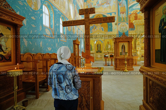 Прихожанка ставит свечи в  храме  святых Константина и Елены в Калининграде (2024 год). Редакционное фото, фотограф Ольга Дмитренко / Фотобанк Лори