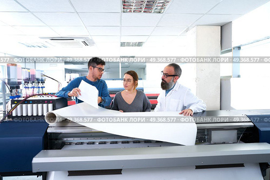 Printing team at industry plotter printer. Printing team at industry plotter printer men and woman. Стоковое фото, агентство Ingram Publishing / Фотобанк Лори