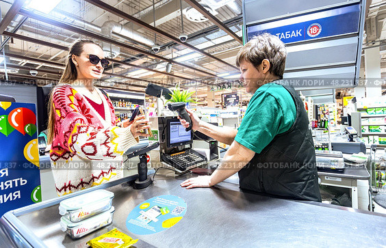 Продавец обслуживает покупателя на кассе в продуктовом магазине «Перекресток» Редакционное фото, фотограф FotograFF / Фотобанк Лори
