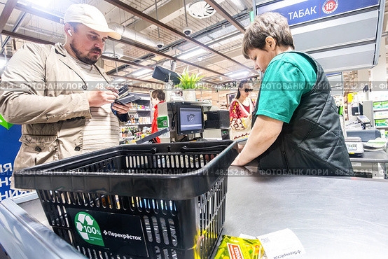 Продавец обслуживает покупателя на кассе в продуктовом магазине «Перекресток» Редакционное фото, фотограф FotograFF / Фотобанк Лори