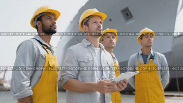 Professional dockworkers wearing safety helmets and overalls collaborating during maritime operations. Analyzing cargo logistics with shared clipboard. Стоковое AI-видео, аниматор Юрий Поздников / Фотобанк Лори
